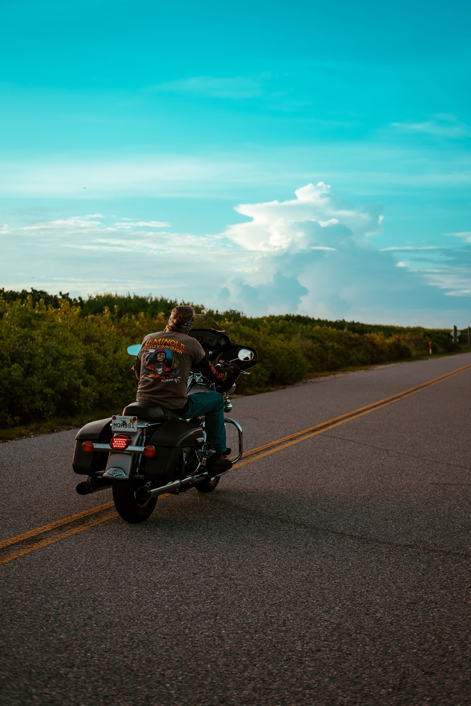 Motorcycle rider on an open Texas highway under a wide clear sky