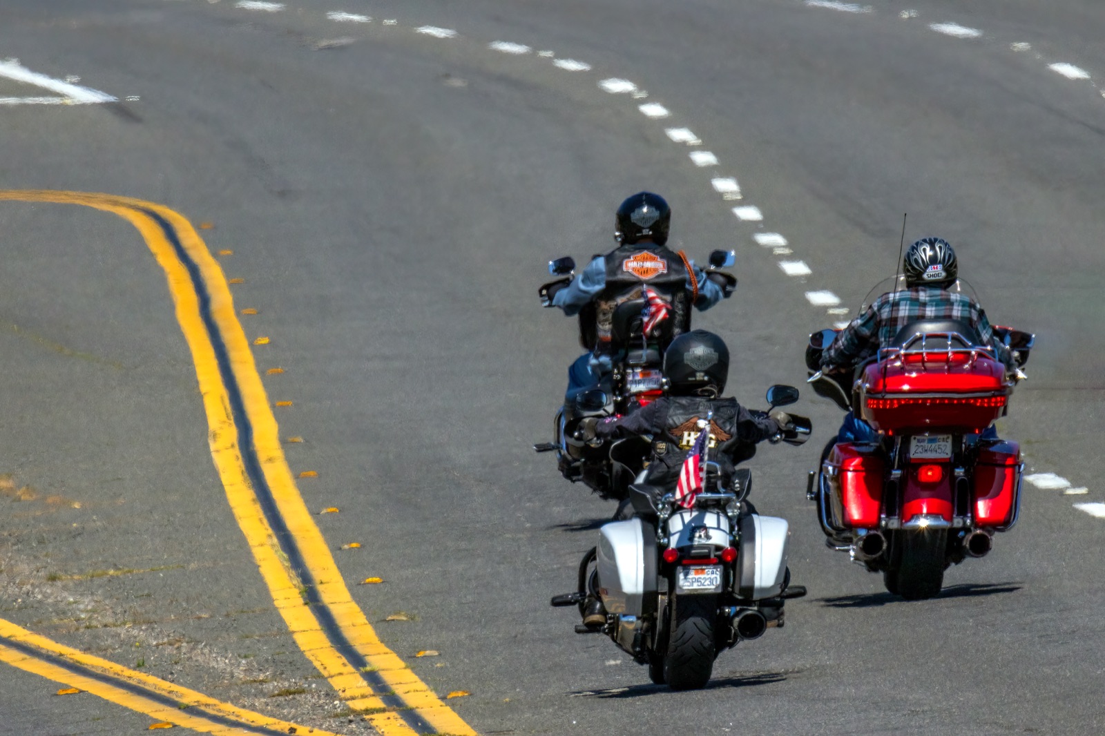 Motorcyclist riding between lanes of slow highway traffic on a wide, flat Texas interstate