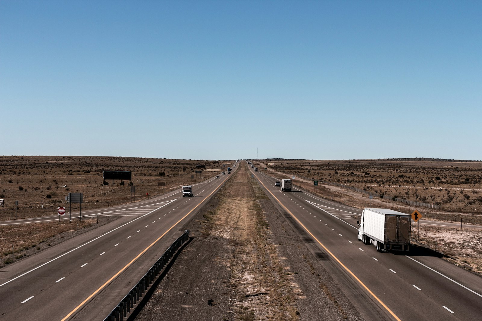 Tractor-trailers on a flat Texas interstate under a wide open sky